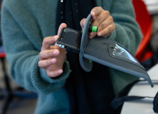 student putting cellphone in pouch
